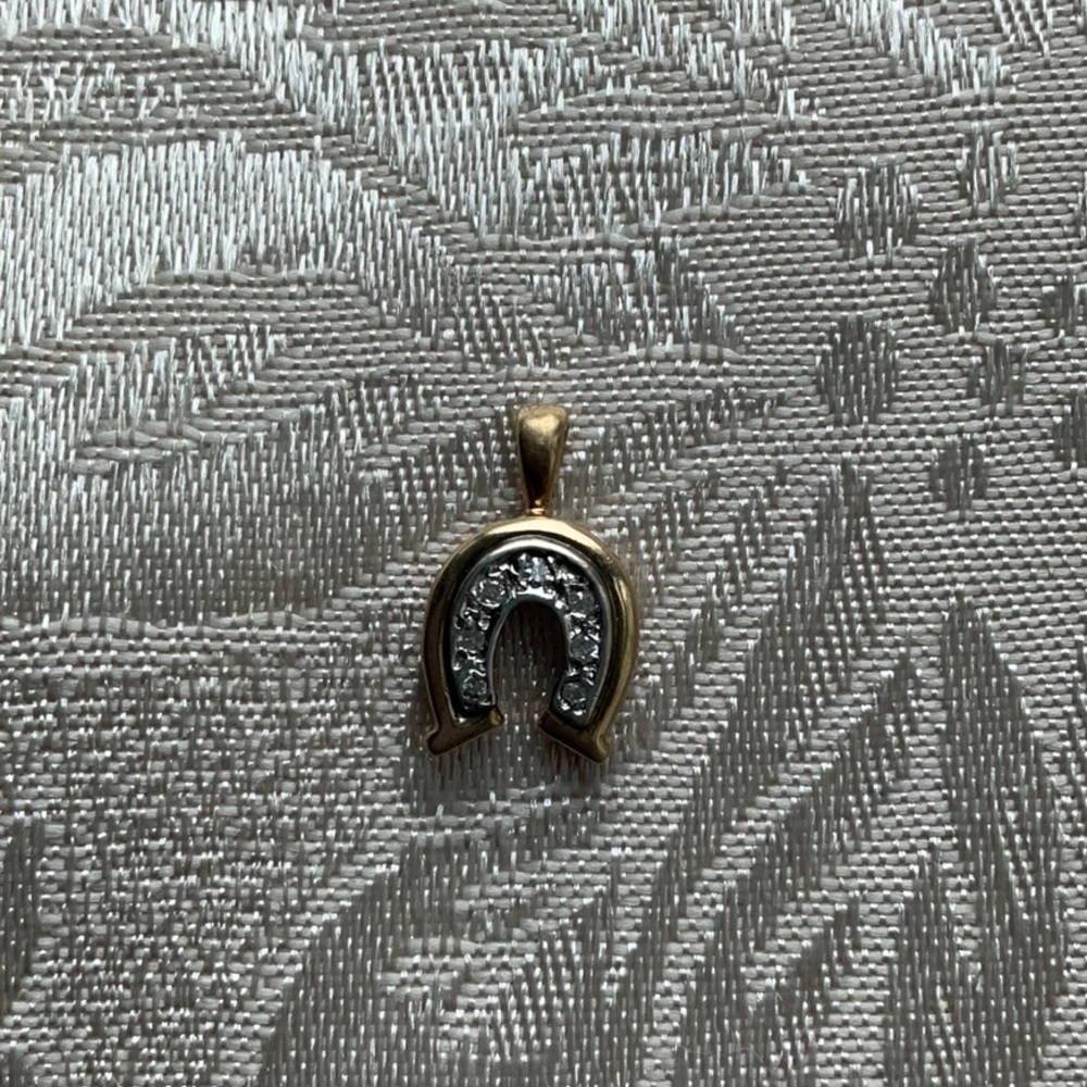 Gold horseshoe pendant or charm with diamonds.